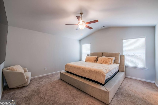 carpeted bedroom featuring a ceiling fan, lofted ceiling, visible vents, and baseboards