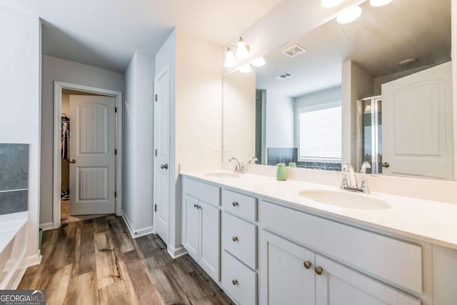 bathroom featuring visible vents, a sink, and wood finished floors