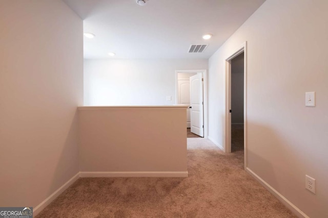 corridor featuring carpet floors, baseboards, visible vents, and recessed lighting