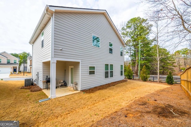 back of property with a patio area, fence, central AC, and a yard