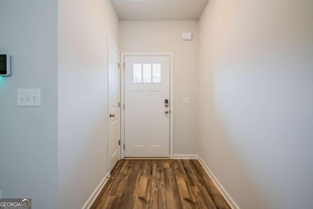 doorway to outside with dark wood-style flooring and baseboards