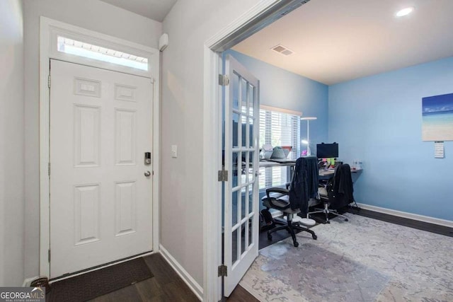 entrance foyer with wood finished floors, visible vents, and baseboards