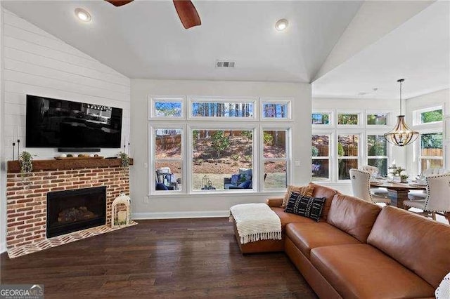 sunroom / solarium with lofted ceiling, ceiling fan with notable chandelier, a fireplace, and visible vents