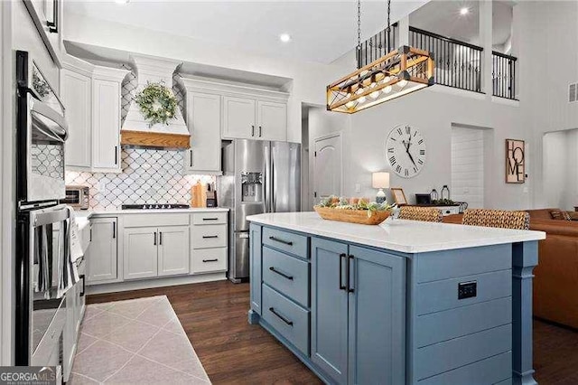 kitchen with premium range hood, light countertops, appliances with stainless steel finishes, and white cabinets