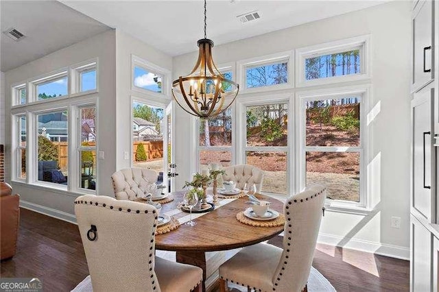 dining space with visible vents, dark wood finished floors, and a chandelier