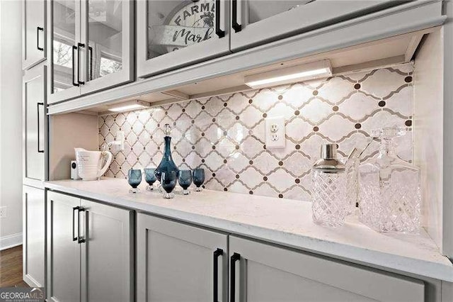 bar featuring tasteful backsplash and dark wood-style flooring