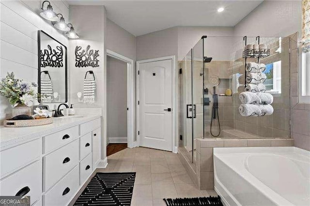 full bath with a stall shower, a garden tub, vanity, and tile patterned floors