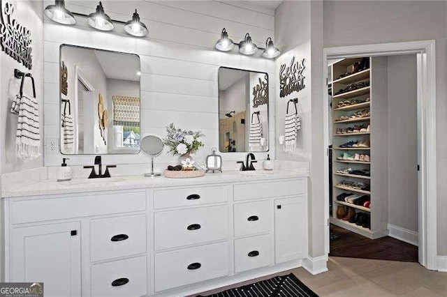 full bathroom with double vanity and a sink