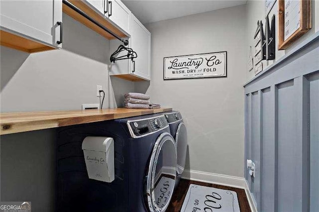 laundry room featuring dark wood-type flooring, independent washer and dryer, cabinet space, and baseboards