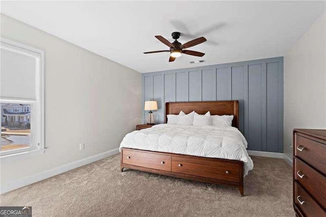 bedroom with visible vents, a ceiling fan, light colored carpet, and baseboards