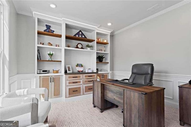 office area with built in features, wainscoting, light colored carpet, crown molding, and a decorative wall