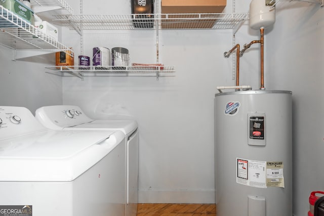 clothes washing area featuring laundry area, water heater, and washer and clothes dryer