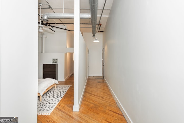 hall with baseboards and wood finished floors