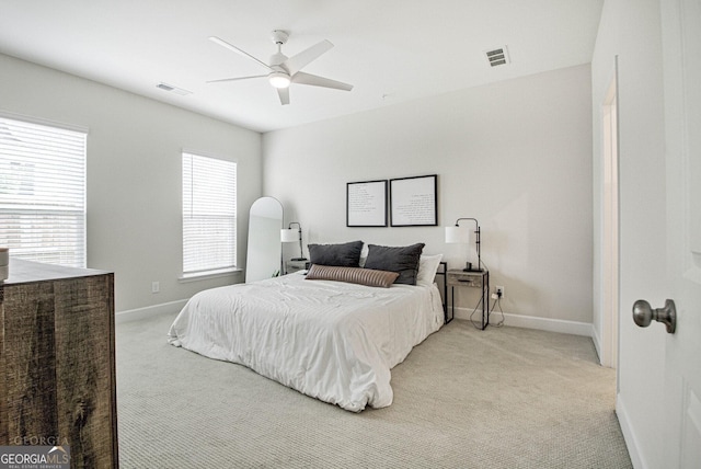 bedroom with light carpet, baseboards, visible vents, and a ceiling fan