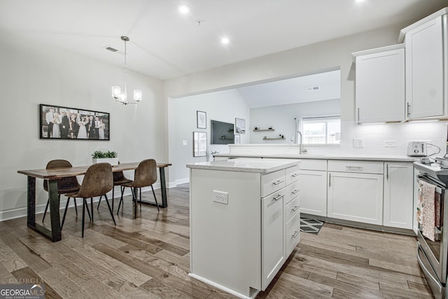 kitchen with visible vents, stainless steel electric range, light wood-type flooring, white cabinetry, and a sink