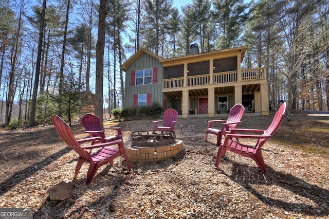 back of house with an outdoor fire pit and a deck