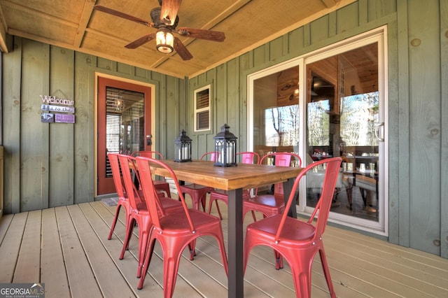 wooden deck featuring outdoor dining area and a ceiling fan