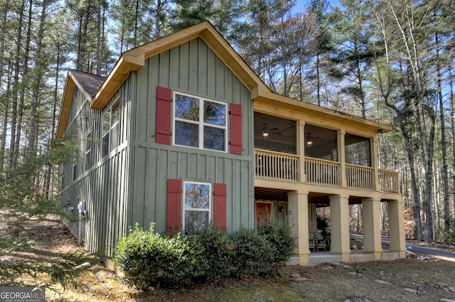 rear view of house featuring a patio area, a sunroom, and board and batten siding