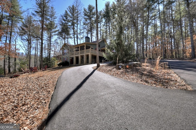 view of front of home featuring a chimney and aphalt driveway