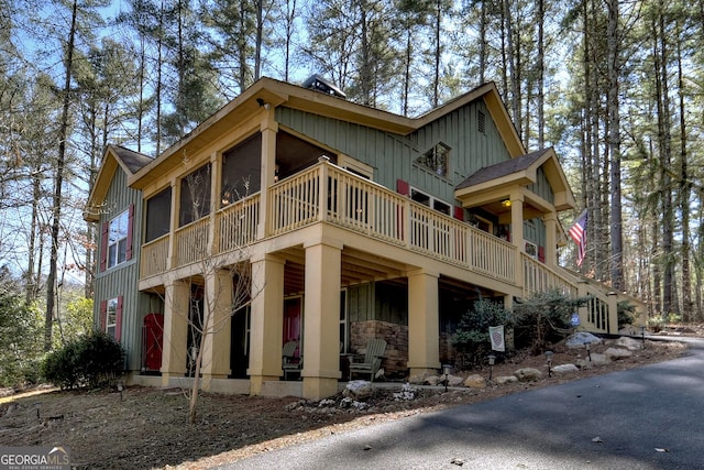 view of side of home with a sunroom, board and batten siding, and roof with shingles