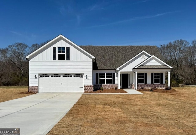 view of front facade with concrete driveway, brick siding, board and batten siding, and a front yard