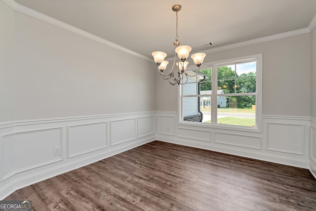 unfurnished dining area with dark wood-style flooring, a wainscoted wall, crown molding, a notable chandelier, and visible vents