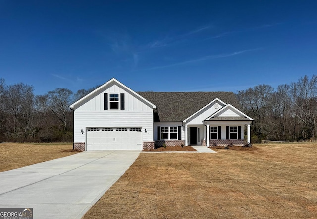 view of front of house with a garage, brick siding, concrete driveway, board and batten siding, and a front yard