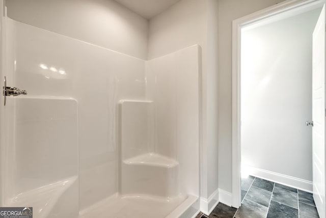 bathroom featuring baseboards and walk in shower