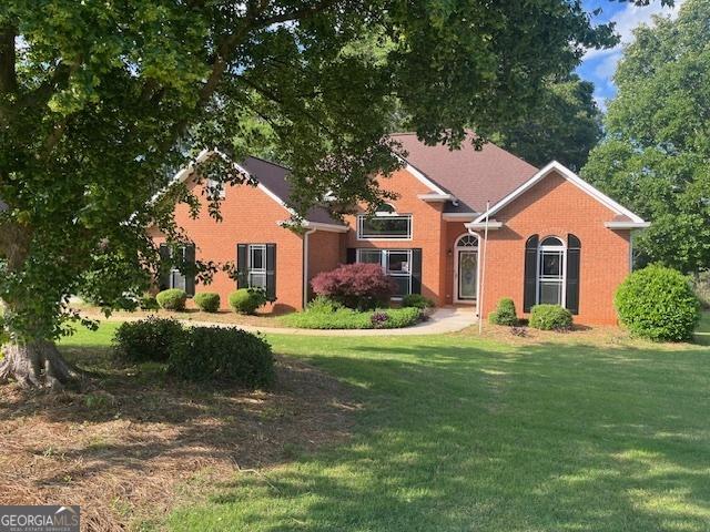 view of front facade with brick siding and a front yard