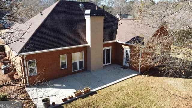 back of house with a patio and a chimney