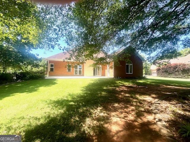 rear view of property featuring a yard