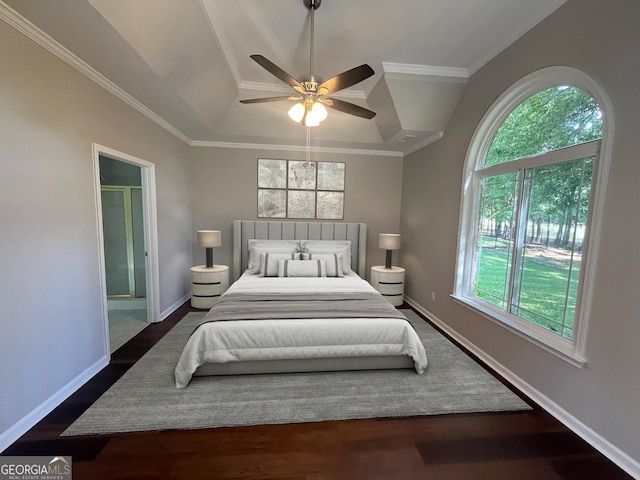 bedroom featuring dark wood-style floors, a raised ceiling, ornamental molding, ceiling fan, and baseboards