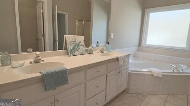 full bath with a garden tub, a sink, and double vanity