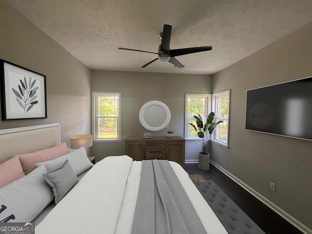 bedroom with a ceiling fan, multiple windows, a textured ceiling, and baseboards