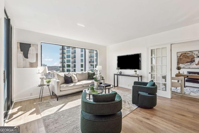 living area featuring baseboards, wood finished floors, and french doors