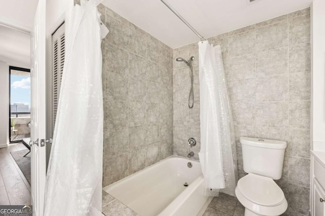 full bathroom featuring toilet, shower / bath combination with curtain, tile walls, and tile patterned floors