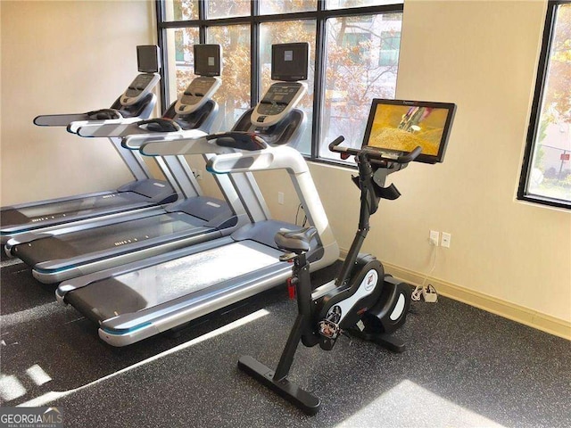 exercise room with plenty of natural light and baseboards