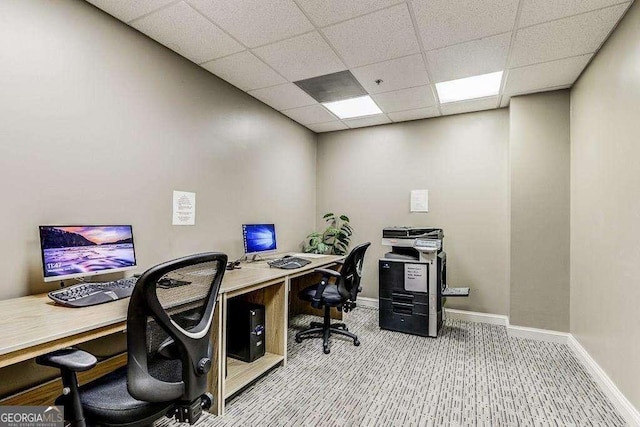 carpeted office featuring a paneled ceiling and baseboards