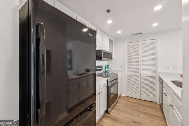 kitchen with visible vents, light wood-style flooring, appliances with stainless steel finishes, light countertops, and white cabinetry