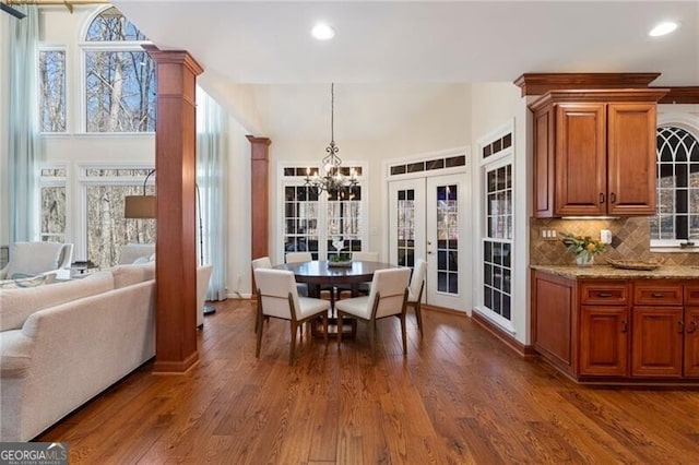 dining room with dark wood-style flooring, french doors, ornate columns, a chandelier, and recessed lighting