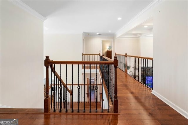 corridor featuring baseboards, wood-type flooring, ornamental molding, an upstairs landing, and recessed lighting