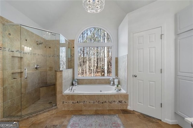 full bath with a stall shower, vaulted ceiling, and a bath