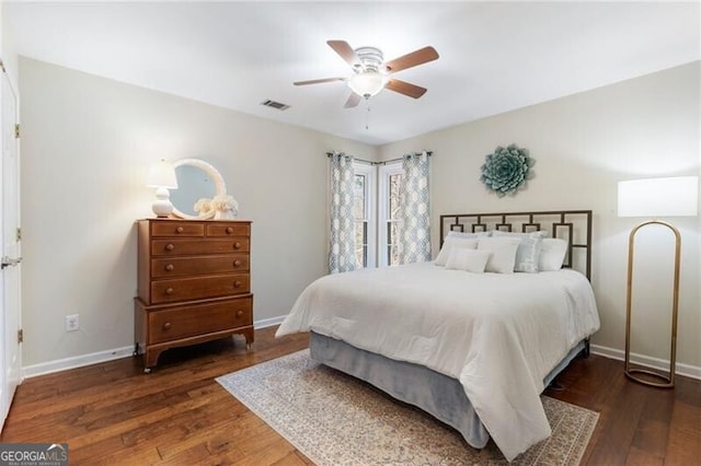 bedroom featuring baseboards, visible vents, and wood finished floors