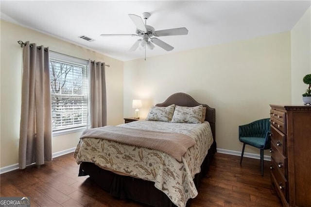 bedroom with dark wood-style flooring, visible vents, and baseboards