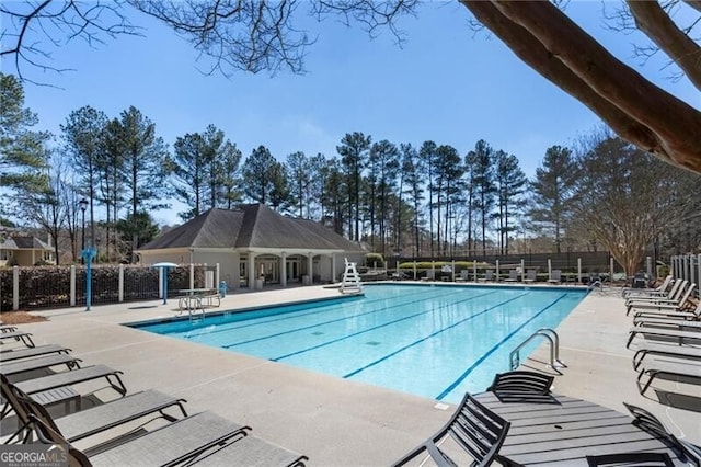 community pool with a patio and fence