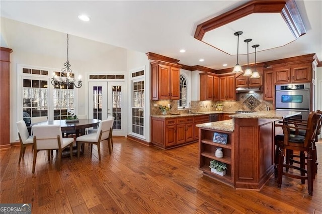 kitchen featuring french doors, brown cabinetry, dark wood finished floors, and light stone countertops