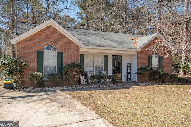 single story home featuring brick siding and a front yard