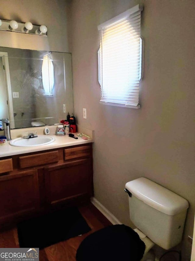 bathroom with toilet, a wealth of natural light, and vanity