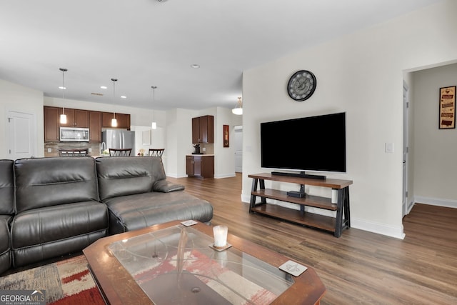 living area featuring dark wood-style floors, recessed lighting, and baseboards