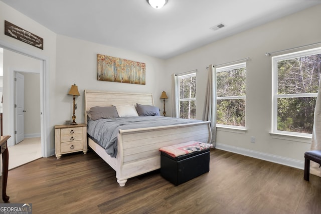 bedroom featuring dark wood-style floors, visible vents, and baseboards